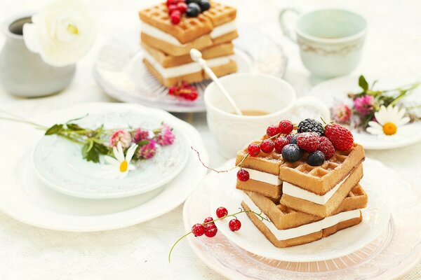 Still life breakfast, waffles with cream and berries and chamomile tea