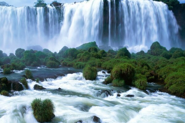 Cascata tempestosa che attraversa il fiume, tra il verde