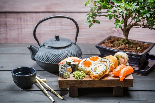 Sushi and rolls with soy sauce and kettle