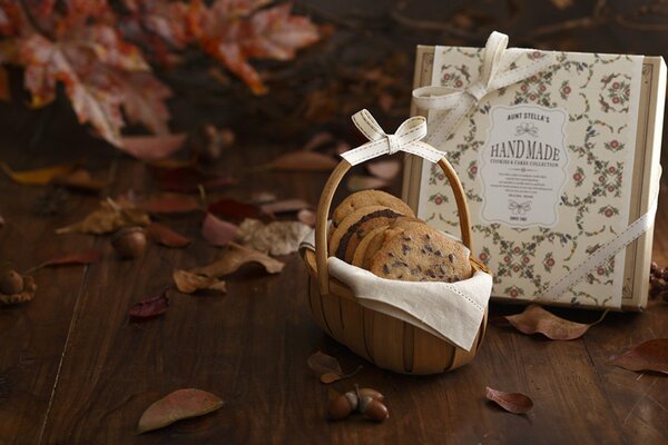 Naturaleza muerta de otoño con hojas, cesta de galletas con chispas de chocolate