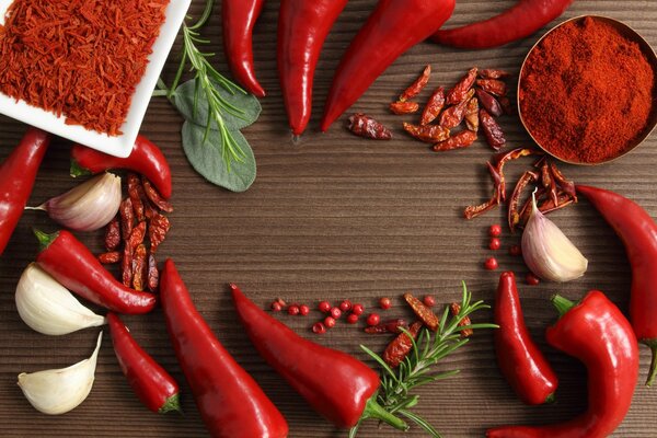 Spices such as garlic, red pepper and rosemary sprigs are on the table