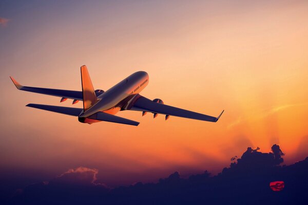 The plane takes off against the background of sunset