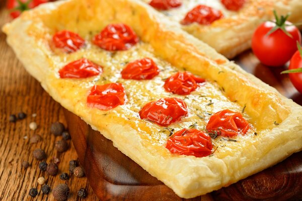 Gâteau de pâte feuilletée avec des tomates sur un tableau noir