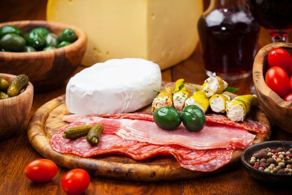 A dish of cheese, meat and cucumbers