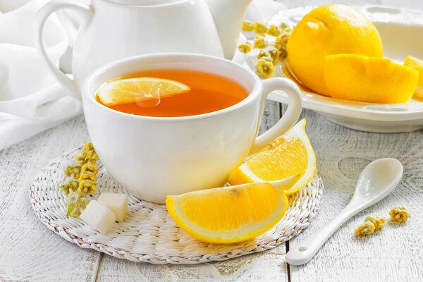 Tè al limone, spicchi di limone e limone intero