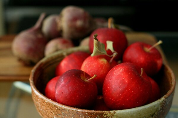 A plate with liquid apples on the background of a plate with beets