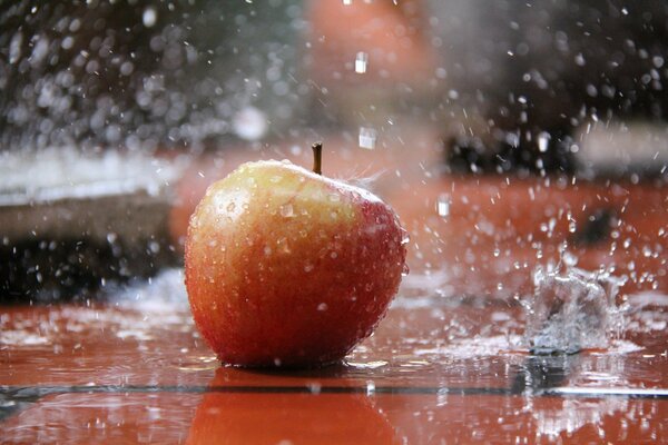 Splashes of water fall on the apple