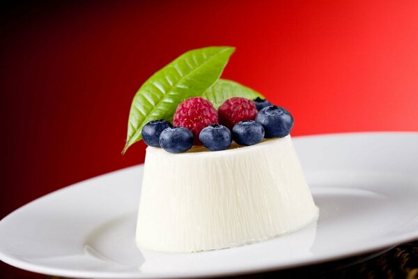 Schneeweißes Dessert mit Blaubeeren und Himbeeren