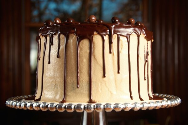 White cake in chocolate glaze on a stand