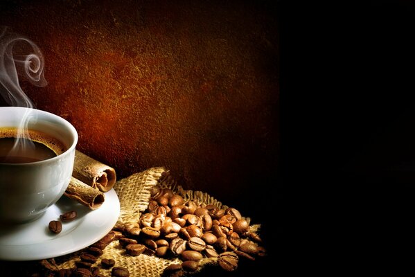 Coffee beans scattered next to the cup