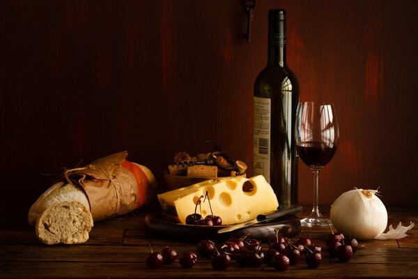 Bouteille de vin rouge avec du fromage et des cerises