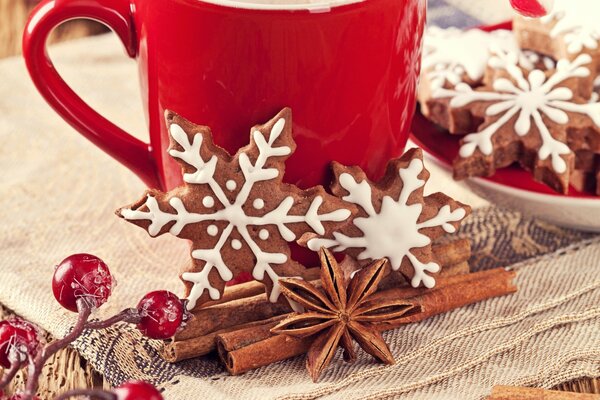 Weihnachtskekse auf dem Hintergrund eines roten Bechers