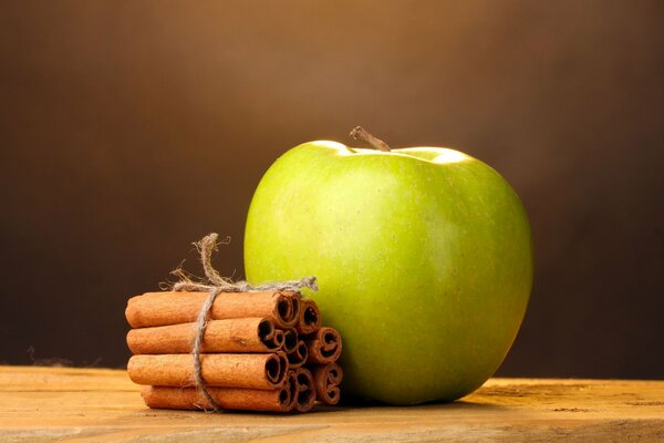 Widescreen shot of an apple with cinnamon sticks