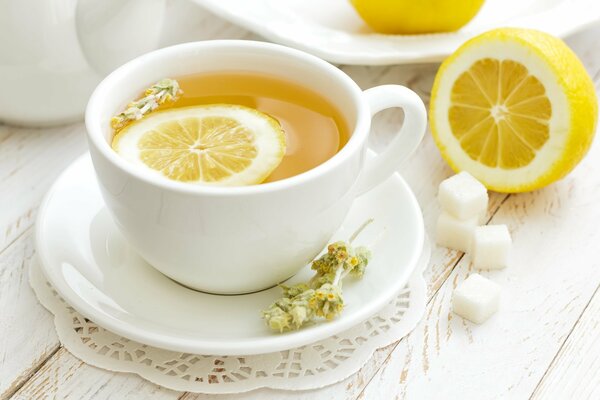 Fragrant tea with lemon and sugar in a white cup