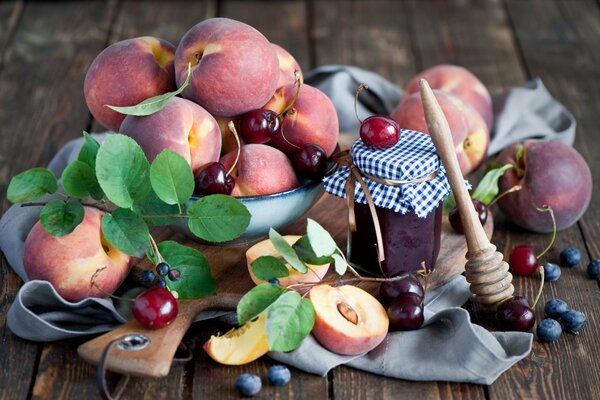 Naturaleza muerta de melocotones y bayas. Fruta en la mesa