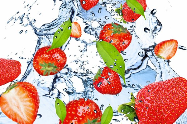 Strawberries in a stream of fresh water with splashes