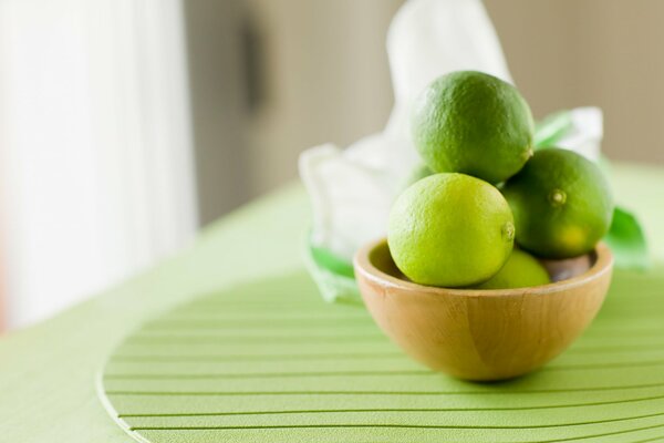 Lime verde in un piatto su un supporto verde