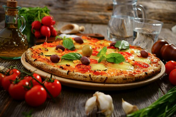 Pizza mit Oliven und nebeneinander liegenden Kirschtomaten