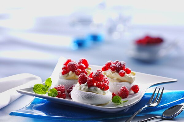 Postre con crema, frambuesas y grosellas rojas