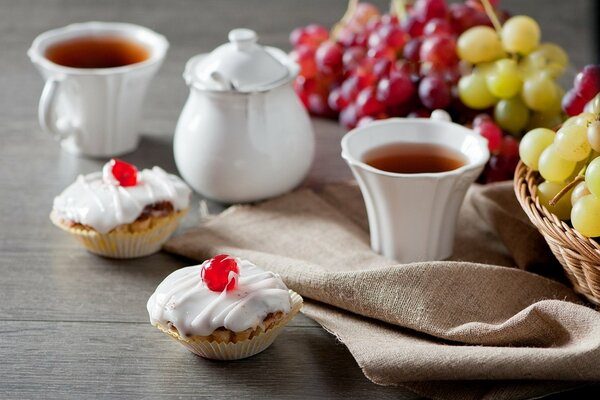 Tea with cakes and grapes on the table