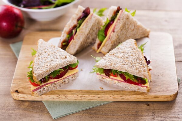 Vier Sandwiches liegen auf einer Tafel