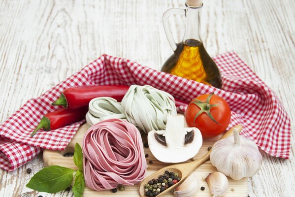 Pâtes aux champignons, tomates, poivrons et ail sur une planche