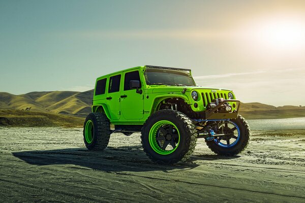 Une Jeep roule sur le sable près des collines