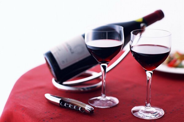 Two wine glasses on a red tablecloth