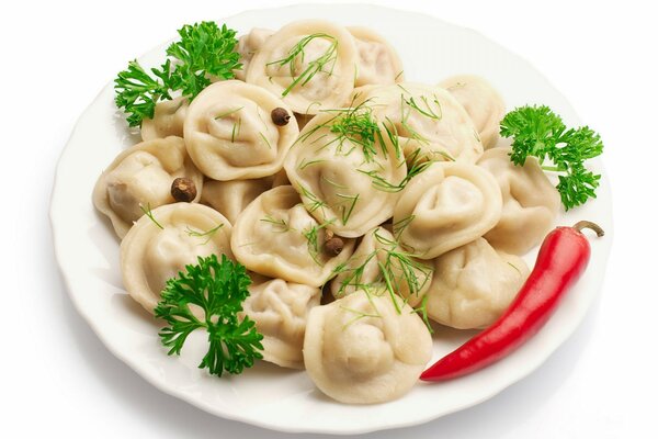 Dumplings with pepper and parsley on a white plate