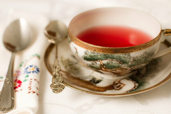 Tazza di tè con piattino e cucchiaini