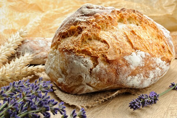 Composition of fresh crusty bread and lavender flowers