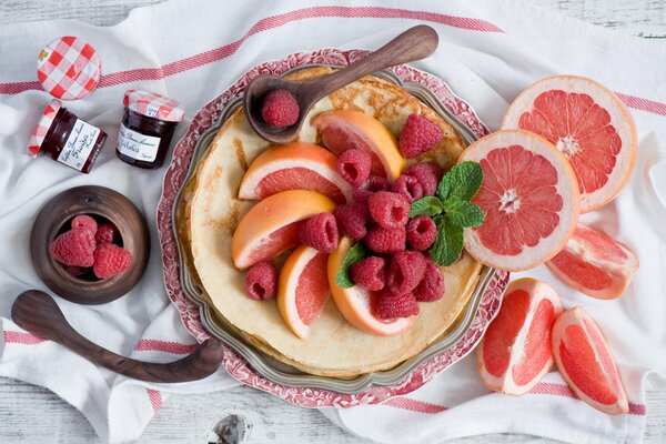 Panqueques con frambuesas y pomelo en un bonito plato