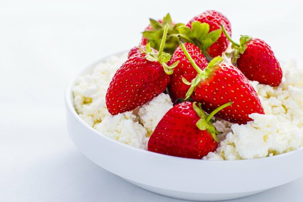 Fraise avec fromage Cottage dans une assiette sur fond blanc