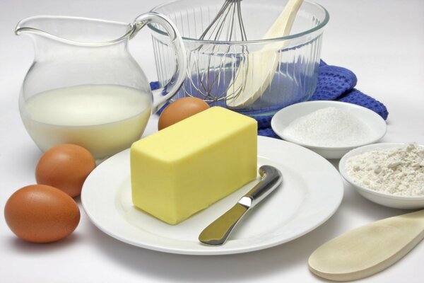 Ensemble de produits sur la table . Beurre, lait, œufs, farine et couverts