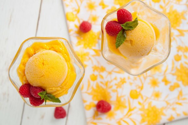 Helado amarillo en crema con bayas de frambuesa