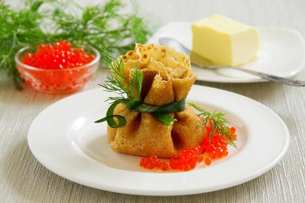 A pancake in the shape of a knot with red caviar