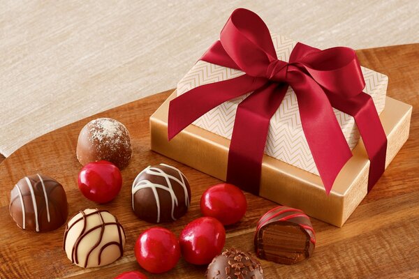 Cioccolatini e confezione regalo con nastro sul tavolo