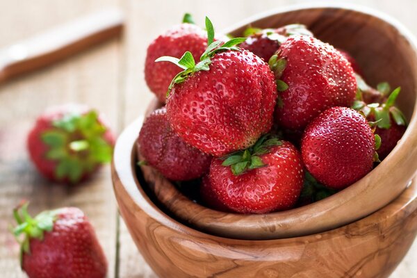 Bacche rosse della fragola in una ciotola di legno