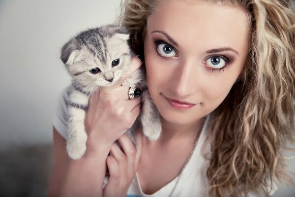 Chica rizada sosteniendo un pequeño gato