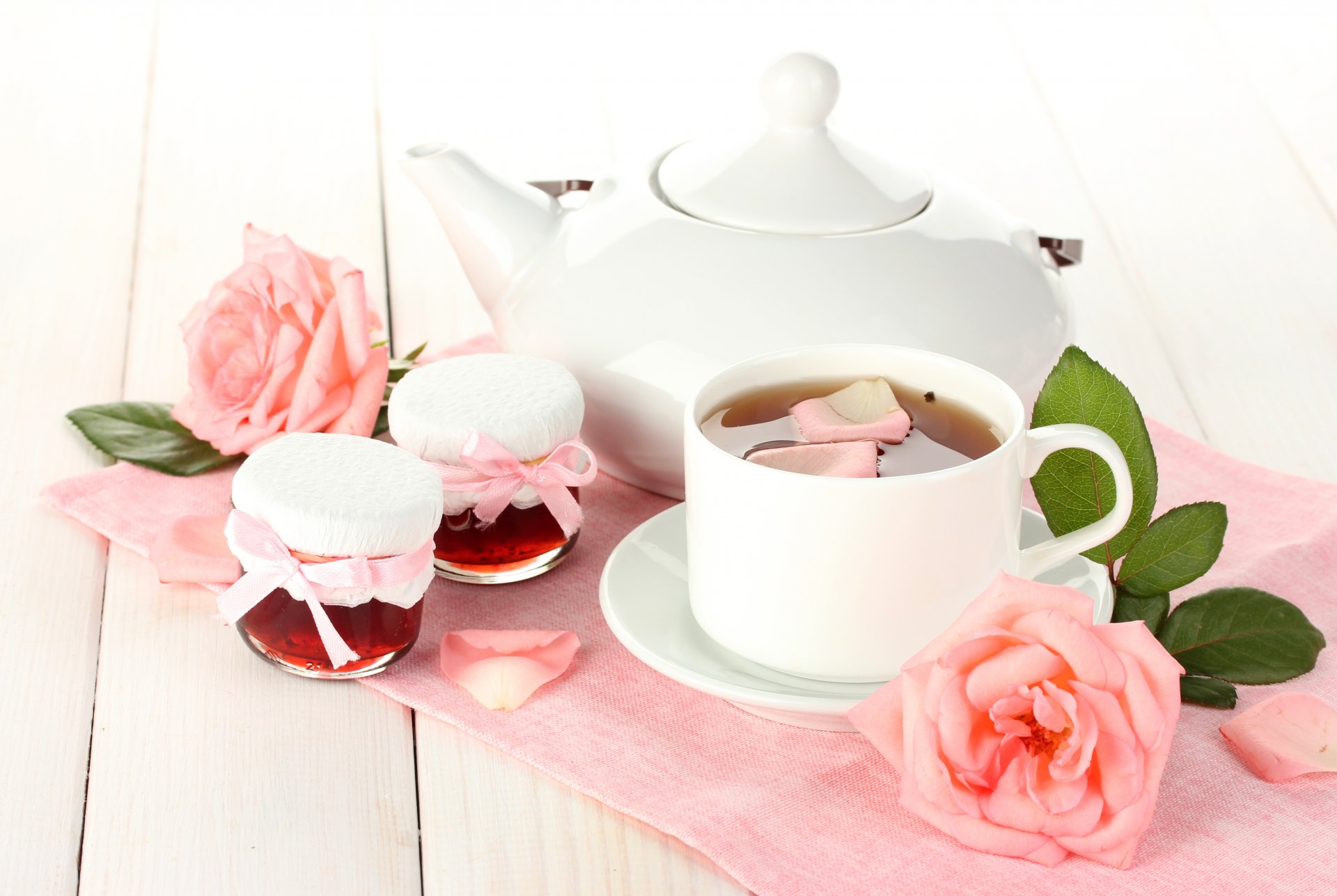 tazza di tè piattino teiera bianco vasetti marmellata marmellata petali foglie di rosa rosa fiori