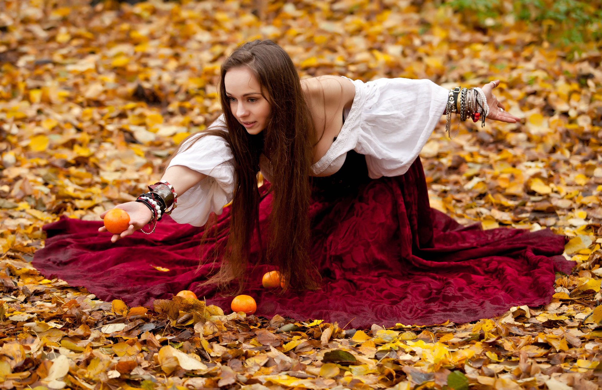 mädchen im kleid mandarinen sitzen laub herbst