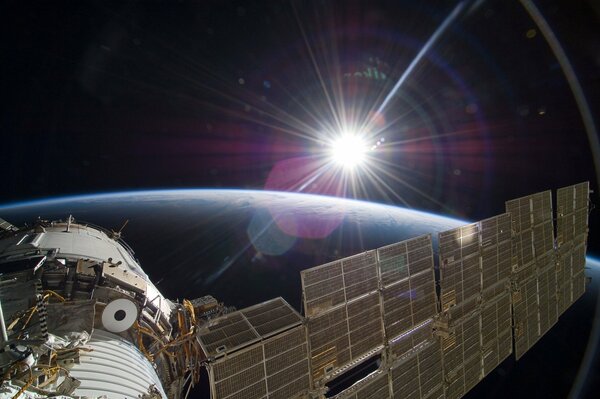 Soyuz spacecraft on the background of the earth and the sun