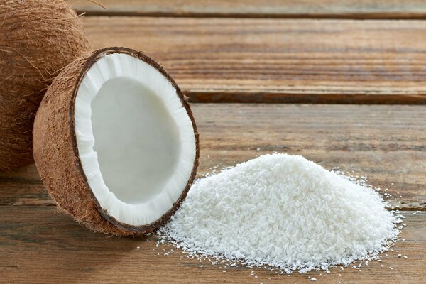 Mezza noce di cocco e trucioli bianchi nelle vicinanze