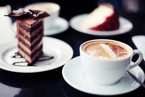 Cappuccino mit einem Stück Kuchen mit Schokolade