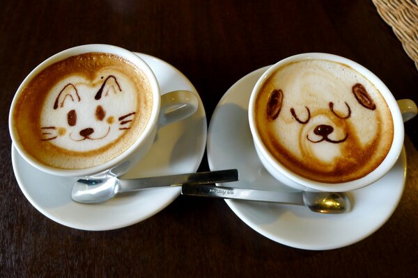 Two cappuccino cups and foam patterns: cat and dog happy