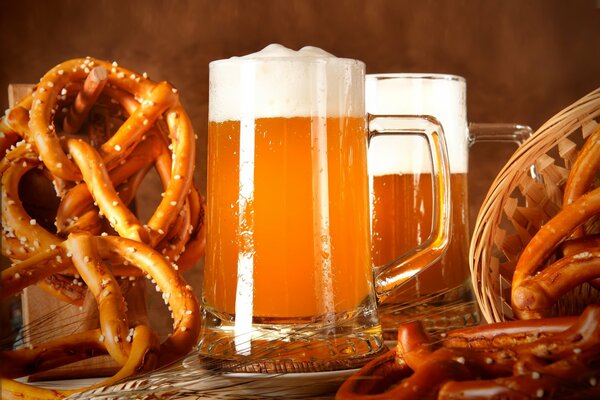 A mug of golden beer and a snack next to it