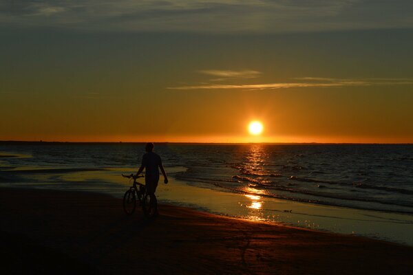 Ein Mann, der am Strand vor dem Hintergrund des Sonnenuntergangs schwärmt