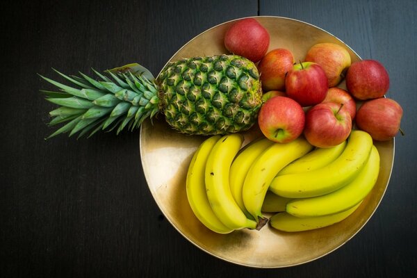 Mela banana e ananas si trovano su un piatto