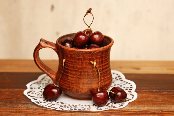 Cherries in a brown mug on a napkin