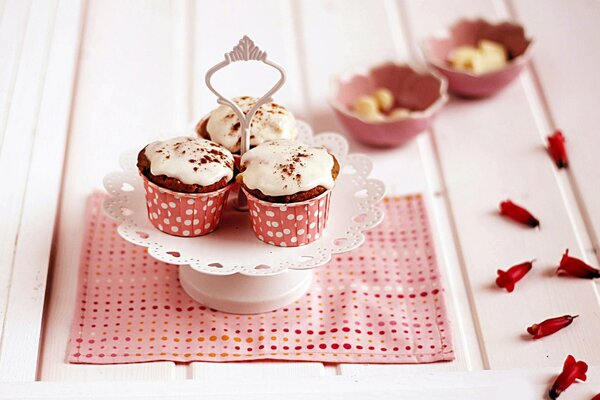 Cupcakes rosados con pétalos en la servilleta